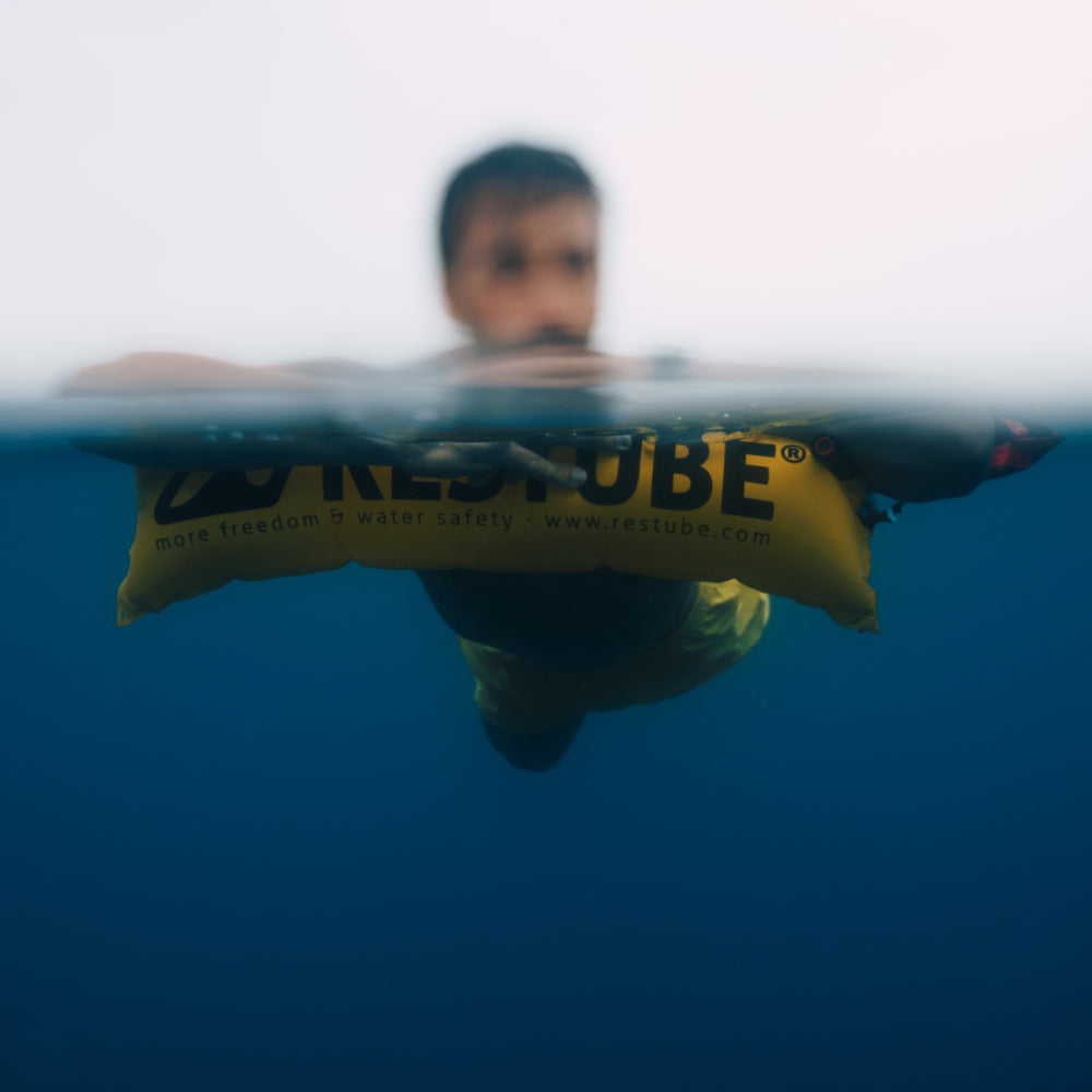 Restube Active - med simmare som vilar på räddningsbojen i vattnet