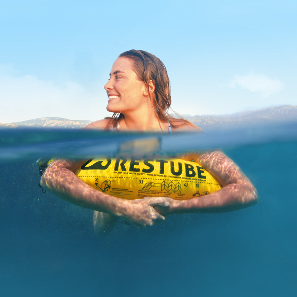 Restube Beach - kvinna som vilar på flytbojen i vattnet